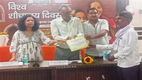 By giving certificates to Swachhata Mitras